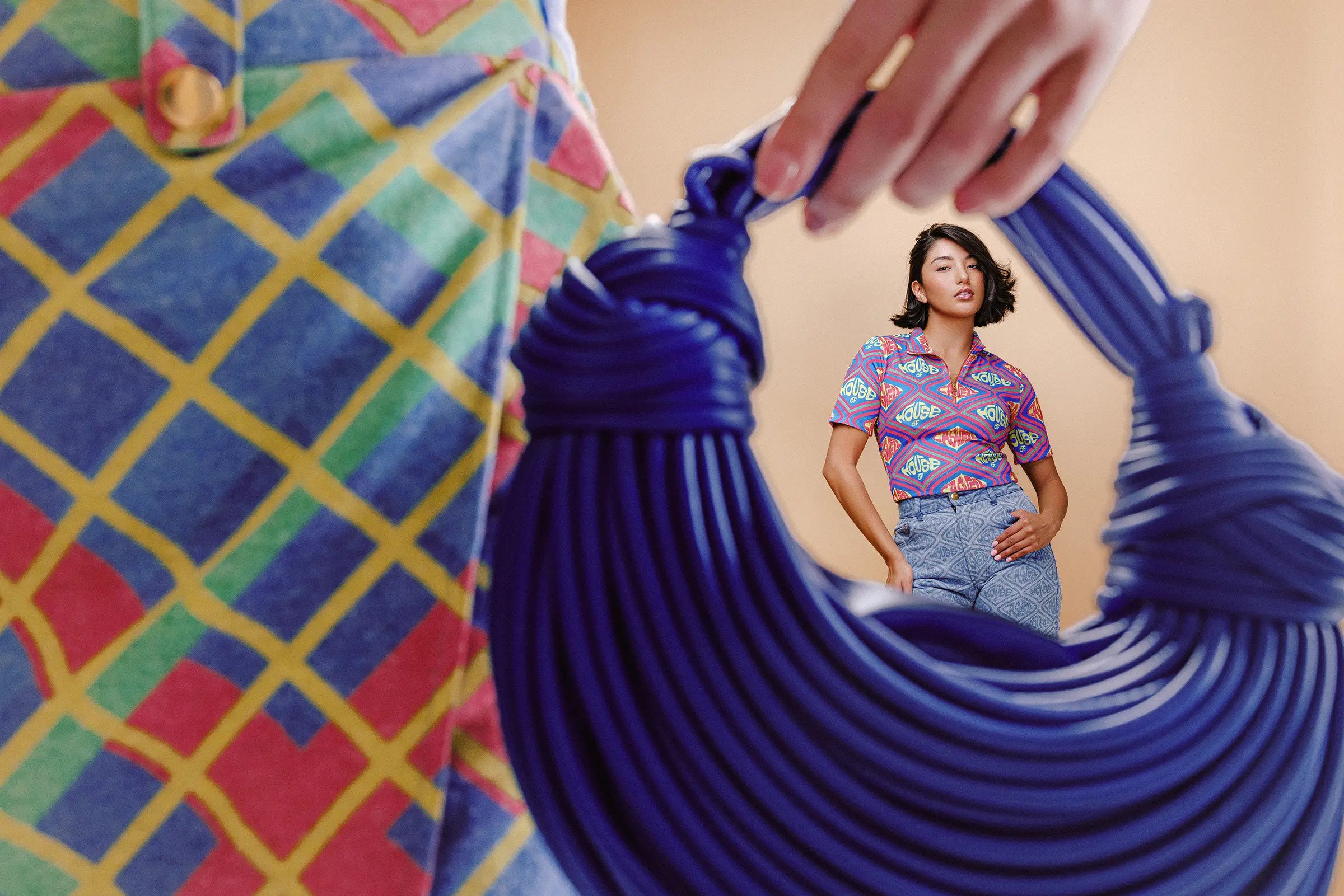 Model framed by sculptural cobalt handbag wearing the Bethany plaid skort by House of Caswell