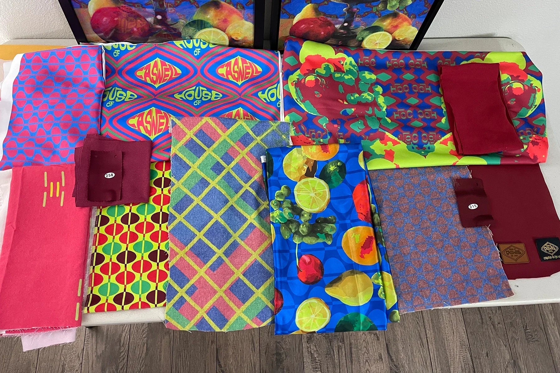 Fabric swatches and printed textiles from the Still Life collection laid out across a studio worktable.